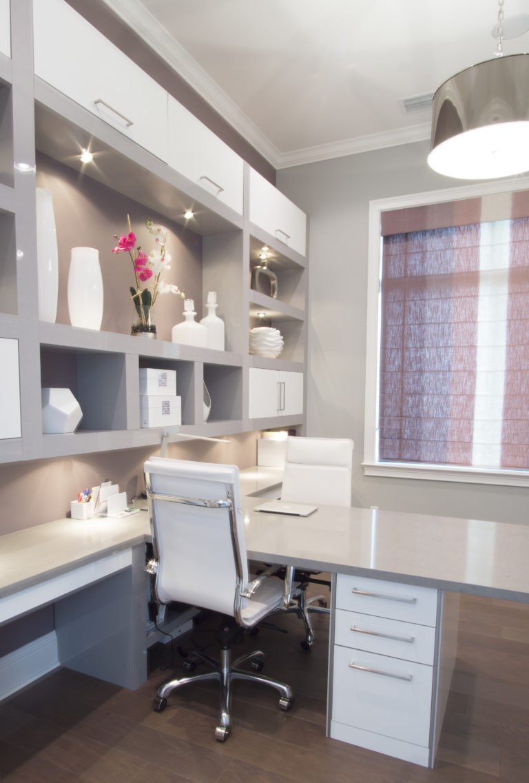 large office desk with floor to ceiling cabinetry and shelves