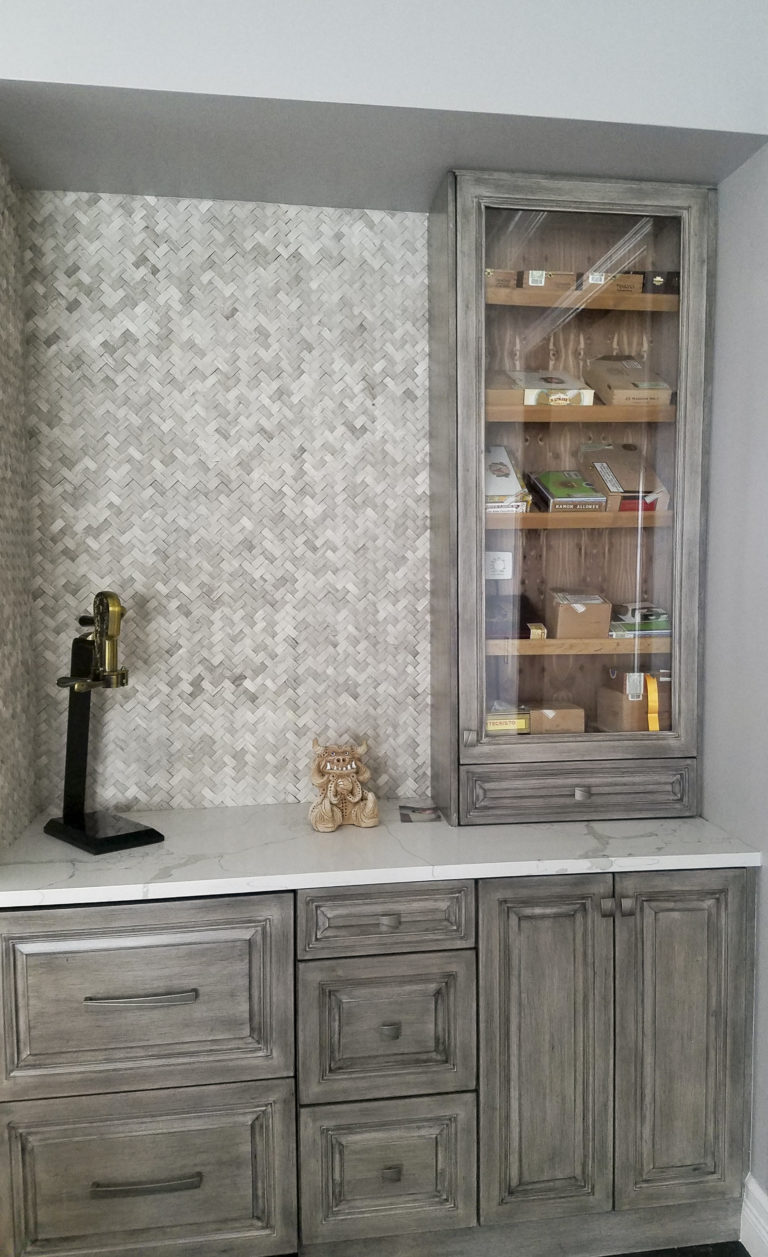 gorgeous wet bar with glass doors on cabinet and beautiful back-splash